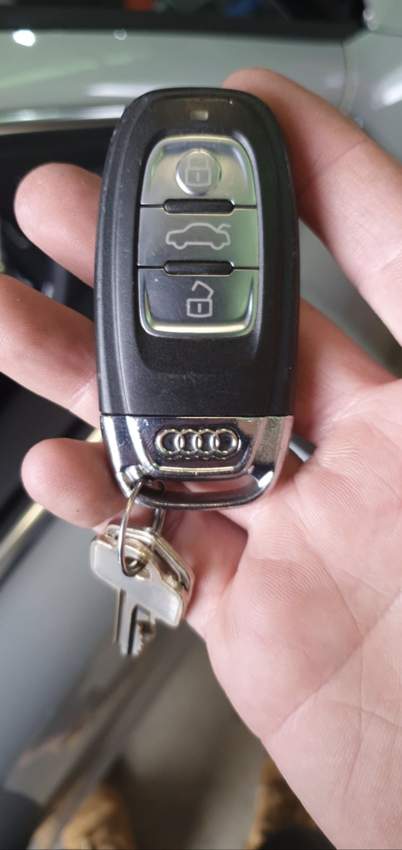 Hand holding an Audi key with Audi four-rings badge visible, All Star Lock + Key job photo